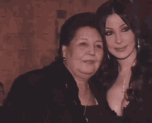 two women are posing for a picture and one has a very large breast