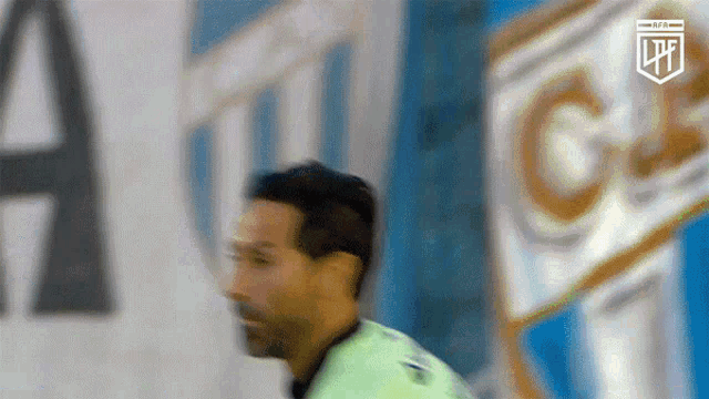 a blurry picture of a soccer player in front of a banner that says lpfl