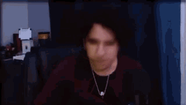 a man is sitting in front of a microphone in a room with his eyes closed and eating something .