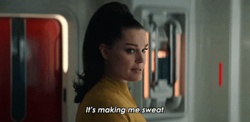 a woman in a yellow sweater is saying `` it 's making me sweat '' .
