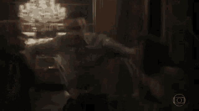a man and a woman are dancing in a room with a chandelier .