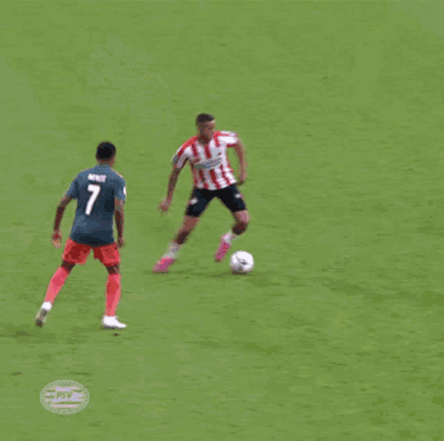 a group of soccer players are playing on a field with a psv logo in the corner