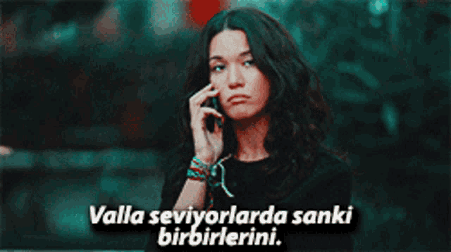 a woman talking on a cell phone with the words valla seviyorlarda sanki birbirlerini written below her