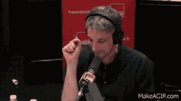 a man wearing headphones sitting in front of a microphone