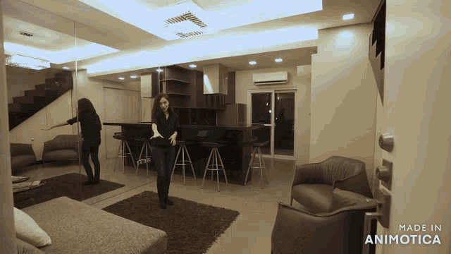 a woman dancing in a living room with the words made in animatica on the bottom