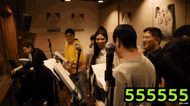 a group of people singing in a room with the number 55555 on the bottom right