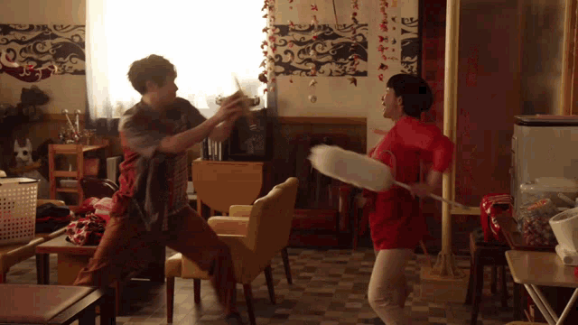 a woman in a red shirt is holding a fan