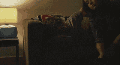 a person is laying on a couch with a lamp in the background