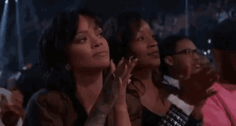 a group of women are sitting in a stadium watching a concert .