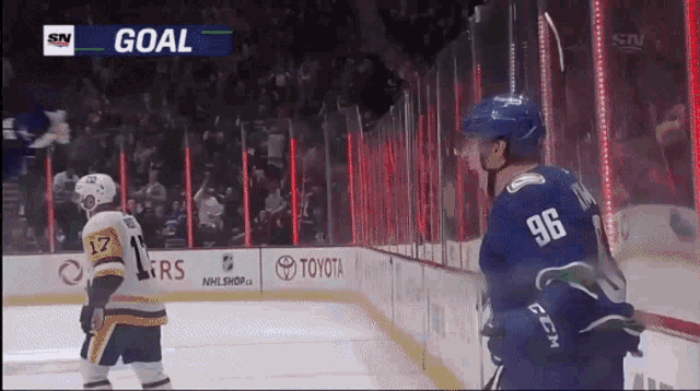 a hockey player with the number 96 on his back stands on the ice