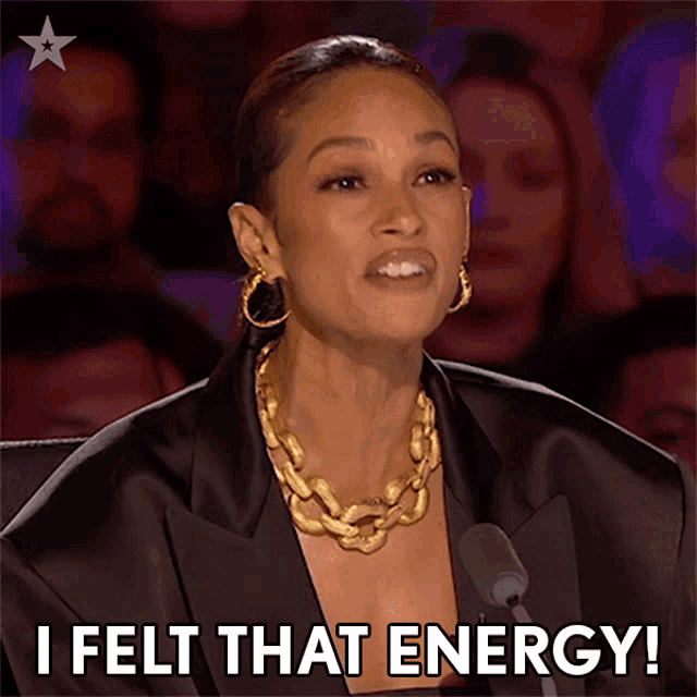a woman in a black jacket and gold necklace says i felt that energy
