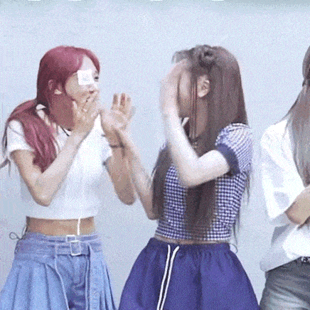 a group of young women are standing next to each other and clapping their hands .