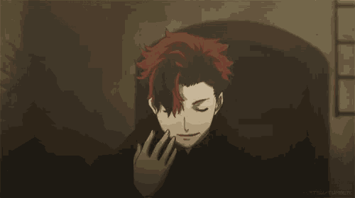 a man with red hair is waving his hand in front of his face .
