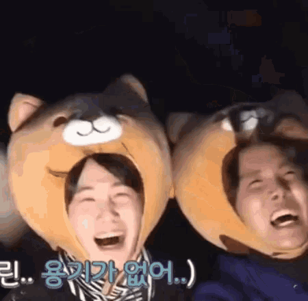 two people wearing stuffed animal hats are laughing and smiling .