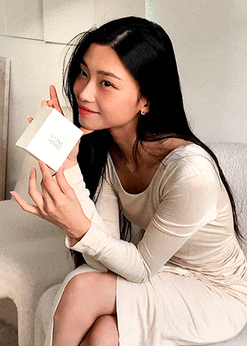 a woman in a white dress is holding a small white box that says ' i love you ' on the front