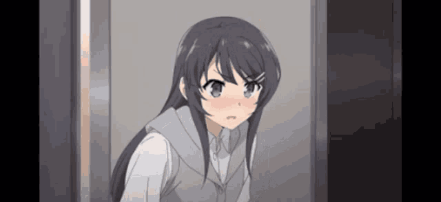 a girl is standing in front of a door with her eyes closed and her mouth open .
