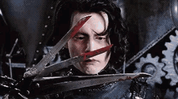 a man is holding a pair of scissors with blood on them .