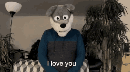 a stuffed animal says i love you while wearing a blue shirt
