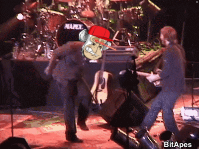 a man in a red hat with a monkey on his head is standing in front of a napex drum set