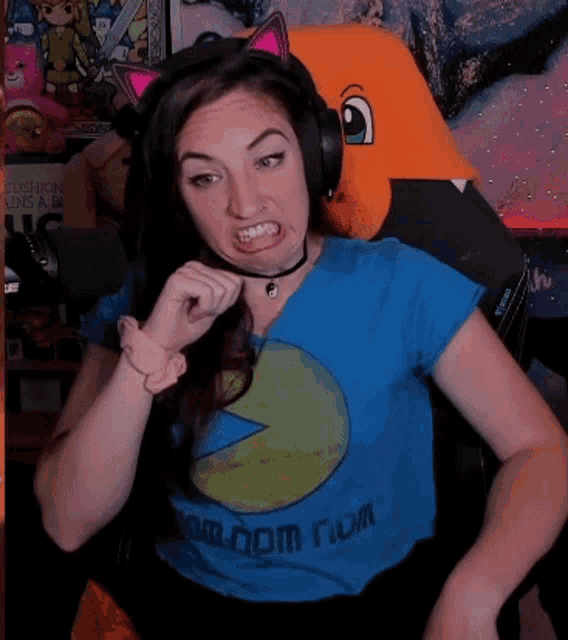 a woman wearing headphones and a blue shirt that says random nom on it