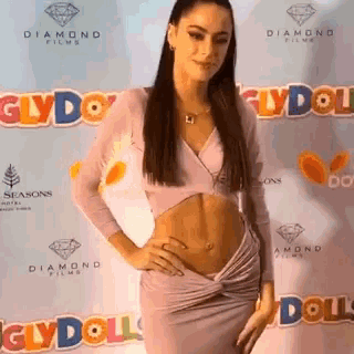 a woman standing in front of a wall that says glydoll