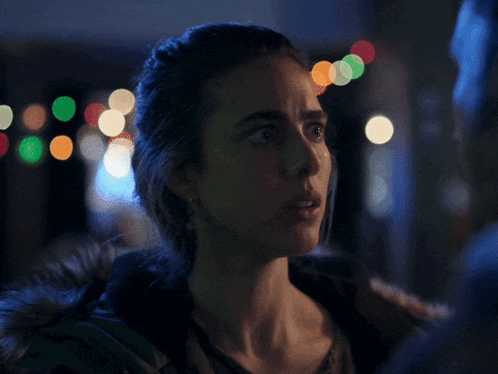 a close up of a woman 's face with lights behind her