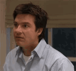 a man in a blue striped shirt is looking at the camera