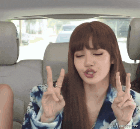 a woman in a car giving a peace sign