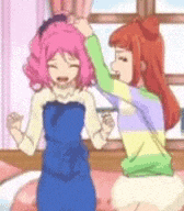 two anime girls are standing next to each other on a bed .