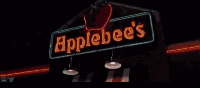 a neon sign for apple 's bar is lit up in the dark
