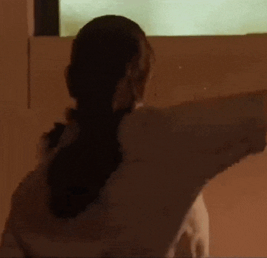 a woman in a white shirt is standing in front of a screen .