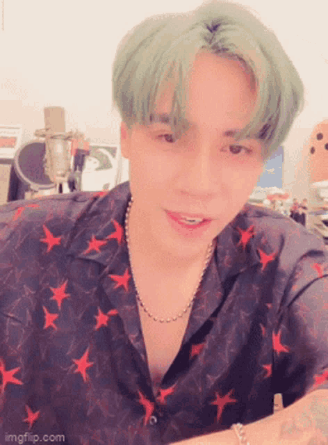 a young man with green hair is wearing a shirt with stars on it