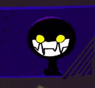 a black circle with yellow eyes and teeth is sitting on a table .