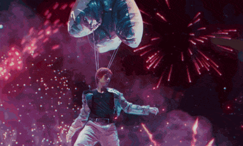 a man is flying through the air while holding a balloon in front of fireworks