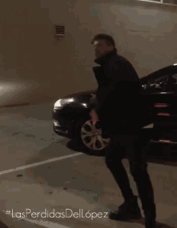 a man is standing in front of a car with #lasperdidasdellopez written on the bottom