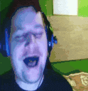 a man wearing headphones is singing into the camera .