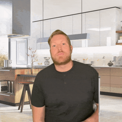 a man with a beard stands in front of a kitchen