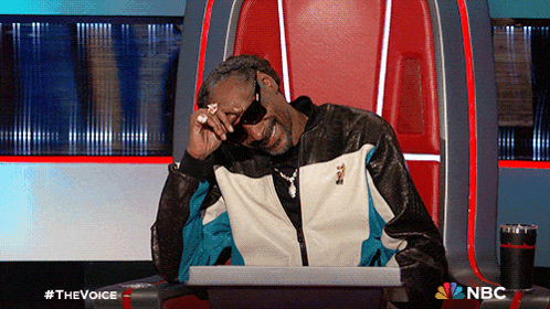 snoop dogg is sitting in a chair with a laptop in front of him on the voice