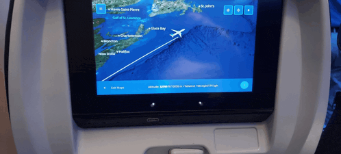 a screen on an airplane shows a plane flying over slate bay