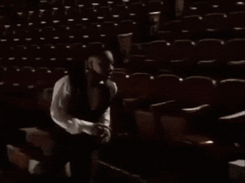 a man in a white shirt is walking down stairs