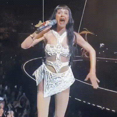 a woman singing into a microphone with her mouth wide open