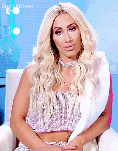a woman with blonde hair is sitting in a chair with smackdown written on the bottom