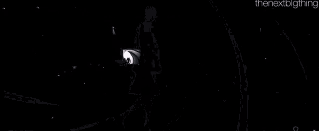 a silhouette of a man in a trench coat walking through a tunnel with the nextbigthing written on the bottom
