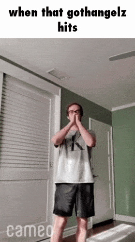 a man is standing in a room with a caption that says when that gothangelz hits