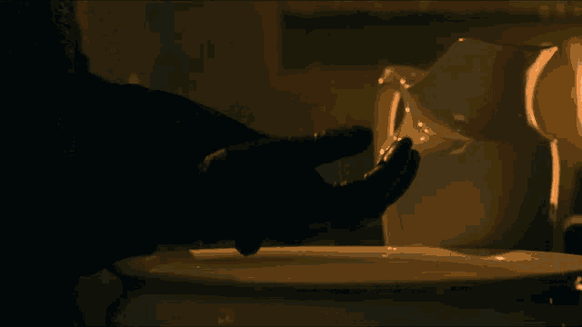 a person 's hand is reaching out towards a pitcher