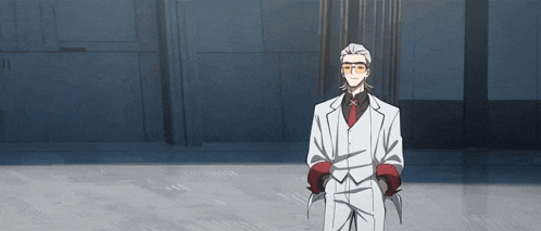 a man in a white suit and red tie is standing in a room with his hands in his pockets