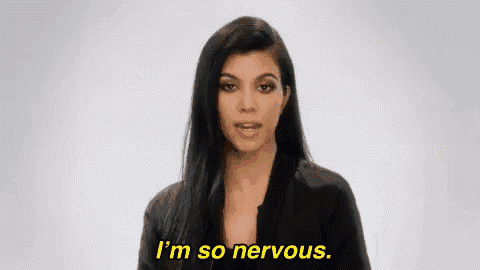 a woman is standing in front of a white background and saying `` i 'm so nervous . ''
