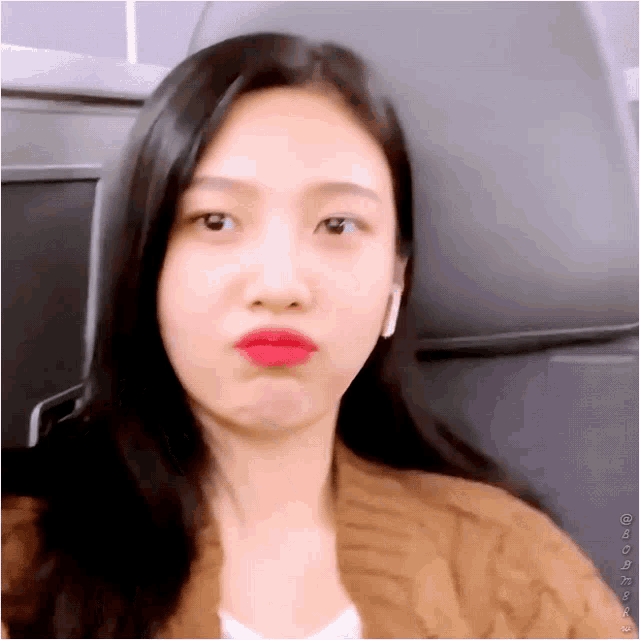 a close up of a woman making a funny face while sitting on a plane .