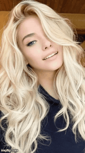a woman with blonde hair and blue eyes is smiling