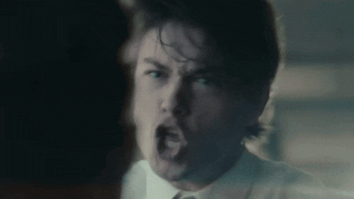 a man in a white shirt and tie is making a funny face with his mouth open